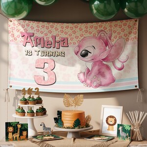 May include: A party scene with a banner that reads "Amelia is turning 3" featuring a pink cartoon character. The table is set with cupcakes, a cake, and safari-themed decorations. Green balloons are suspended above.