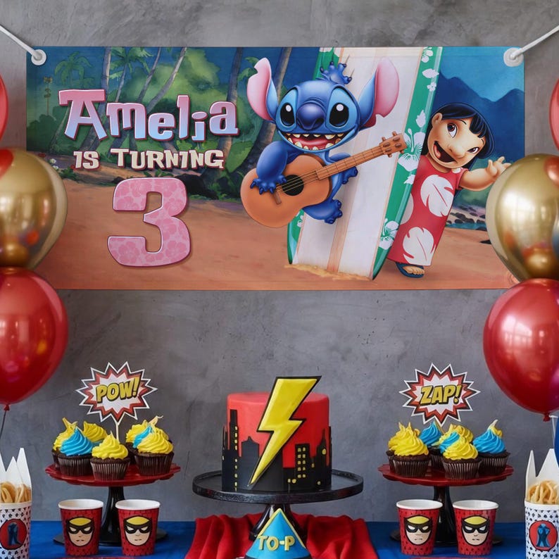 May include: A party scene with a banner saying "Amelia is turning 3." The banner shows cartoon characters Stitch playing a guitar and Lilo with a surfboard. A red and black cake with a yellow lightning bolt sits on a table with cupcakes and superhero-themed cups.