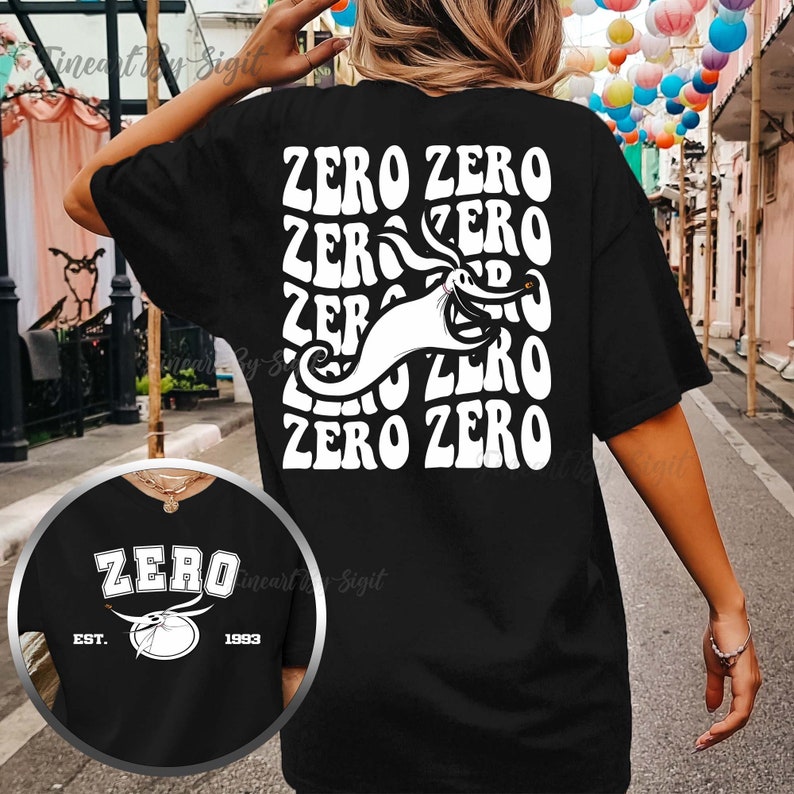 Puede incluir: Camiseta negra con un gr&aacute;fico blanco de Zero de Pesadilla Antes de Navidad. El gr&aacute;fico presenta la cara y el cuerpo de Zero con el texto "ZERO ZERO" repetido en un estilo retro. La parte posterior de la camiseta tiene el texto "ZERO" con una imagen estilizada de la cabeza de Zero y el texto "EST. 1993".