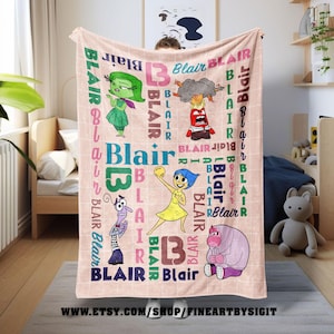 May include: A personalized pink blanket featuring the name "Blair" in various fonts and colors. The blanket includes cartoon characters and the text "Blair" repeated throughout the design. The Etsy shop URL is visible at the bottom.