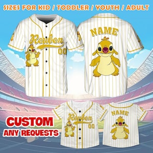 Puede incluir: Jersey de b&eacute;isbol blanco con rayas doradas y un personaje de dibujos animados de Stitch. El jersey tiene un nombre y un n&uacute;mero en la parte delantera y trasera. El texto en la parte delantera dice "Reuben 00" y el texto en la parte trasera dice "NAME".