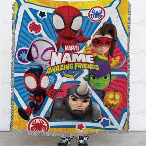 May include: A Marvel Amazing Friends throw blanket featuring Spider-Man, Spider-Gwen, and other characters. The blanket has a colorful design with a blue, yellow, and white background. The blanket is fringed on the edges.