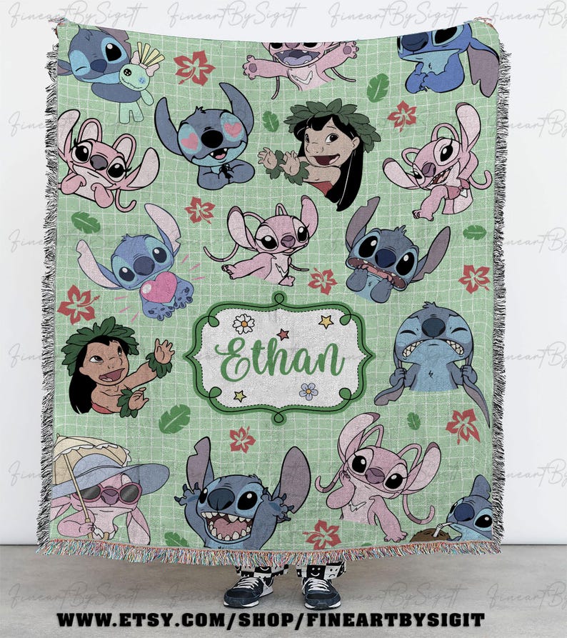 May include: A light green throw blanket featuring cartoon characters, including Stitch and Lilo, with floral and leaf accents. The blanket has a personalized name, "Ethan", in a decorative frame. The blanket has a fringed edge.