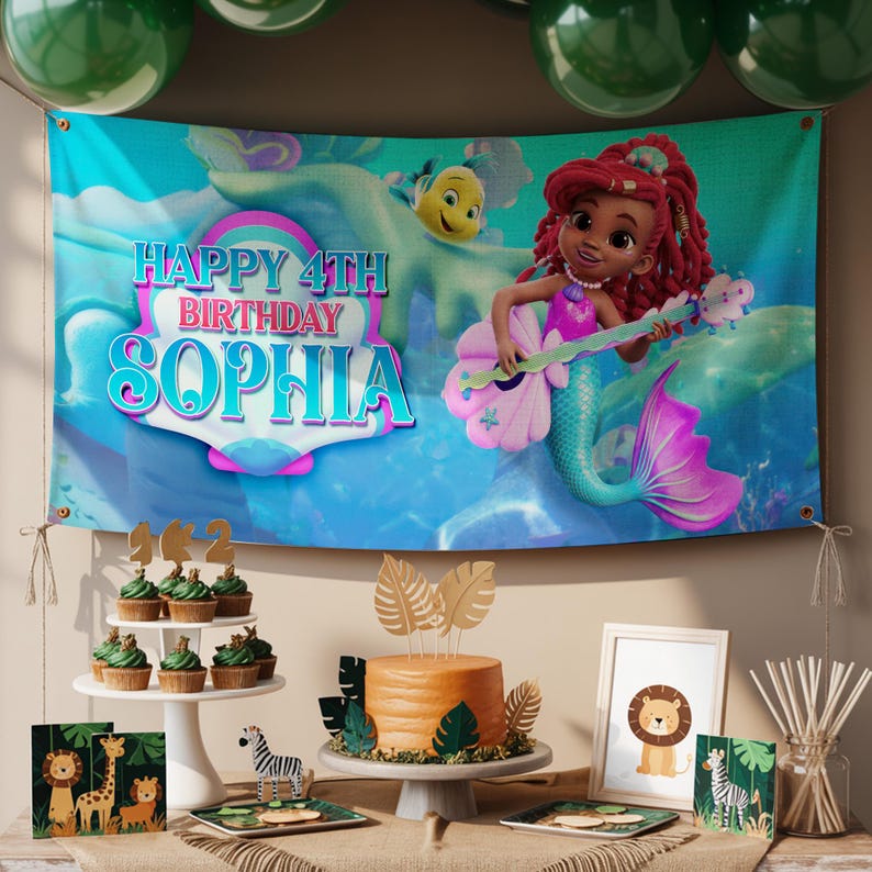 K&ouml;nnte beinhalten: Ein Geburtstagsbanner mit dem Text "HAPPY 4TH BIRTHDAY SOPHIA" und einer Meerjungfrau-Illustration. Die Party beinhaltet Cupcakes, einen Kuchen und Dekorationen mit Tiermotiven. Gr&uuml;ne Luftballons sind im Hintergrund zu sehen.