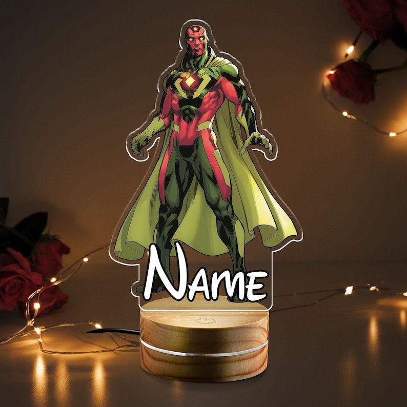 May include: A Vision character night light with a wooden base. The superhero is depicted in his classic red, green, and yellow costume. The word "Name" is written in a stylized font on the front of the light.