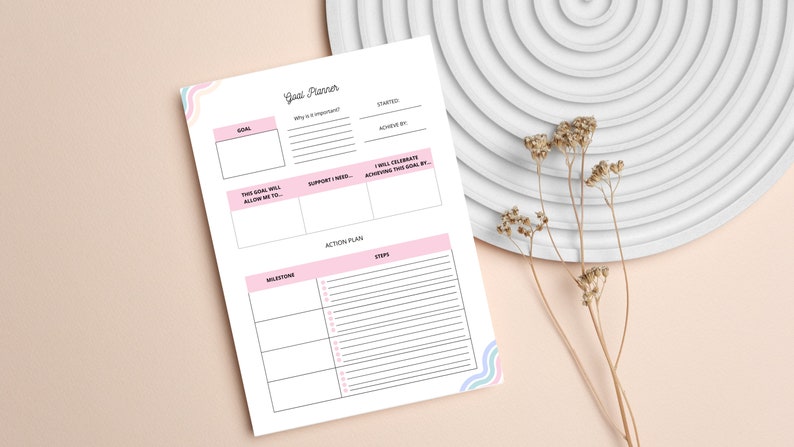 Pode incluir: Um planejador de objetivos imprim&iacute;vel com detalhes rosa e azul. O planejador inclui se&ccedil;&otilde;es para defini&ccedil;&atilde;o de objetivos, planos de a&ccedil;&atilde;o, marcos e etapas. O texto no planejador diz "Goal Planner".