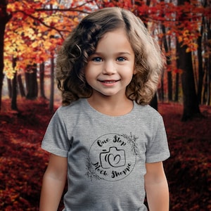 Kids T-Shirt Lifestyle Mockup Athletic Heather Bella+Canvas 3001T Autumn Girl Toddler Model in Crewneck Outside Under Fall Trees with Leaves