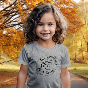 Kids T-Shirt Lifestyle Mockup Athletic Heather Bella+Canvas 3001T Autumn Girl Toddler Model in Crewneck Outside Under Fall Trees with Leaves
