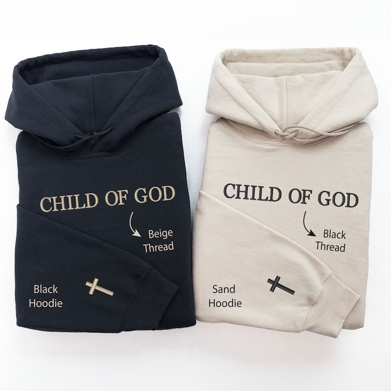 Op de afbeelding: Twee hoodies, een zwarte en een zandkleurige, beide met de tekst "CHILD OF GOD" geborduurd op de voorkant. De zwarte hoodie heeft borduurwerk met beige draad en de zandkleurige hoodie heeft borduurwerk met zwart draad. Beide hoodies hebben een kruis geborduurd op de mouw.