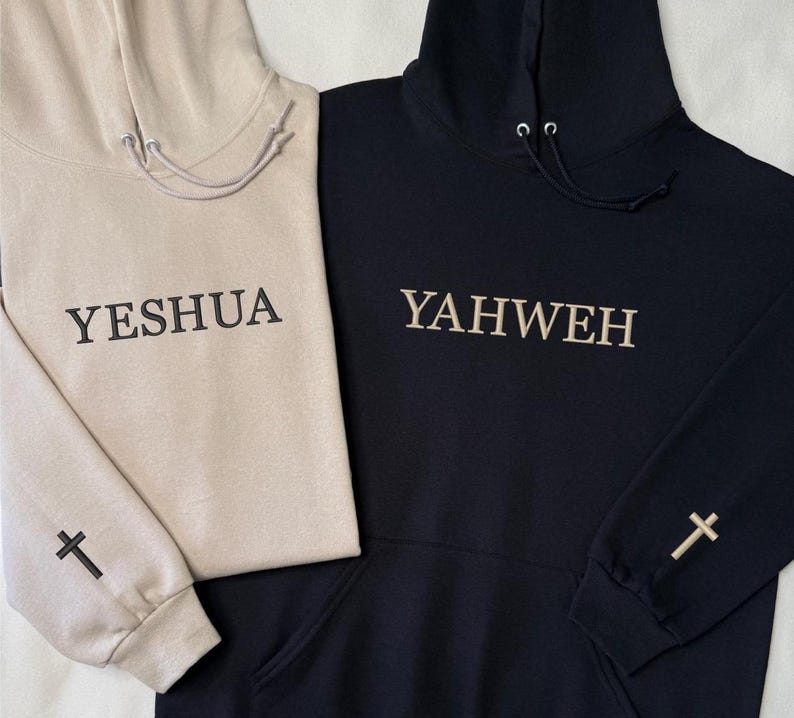 May include: Two hooded sweatshirts, one beige and one black. The beige sweatshirt has the word "YESHUA" embroidered on the front and a cross on the sleeve. The black sweatshirt has "YAHWEH" embroidered on the front and a cross on the sleeve. Both have drawstrings.