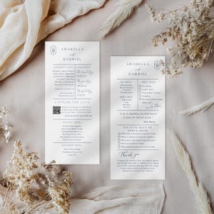 Pode incluir: Dois elegantes cartões de menu de casamento com os nomes Arabella e Gabriel. Os cartões apresentam um design minimalista com texto preto sobre fundo branco. Um cartão lista o cortejo nupcial e o menu, o outro compartilha fatos divertidos sobre o casal.