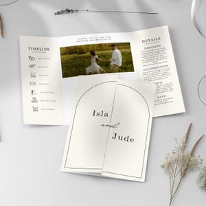 Può includere: Un invito di nozze a tre ante con un design minimalista. L'invito presenta una foto di una coppia, i dettagli dell'evento e i nomi "Isla and Jude". Sono incluse anche la cronologia e le informazioni RSVP. L'invito è stampato su cartoncino bianco.