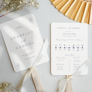 May include: A white wedding fan with a navy blue ribbon and a navy blue design. The fan features the names Arabella and Gabriel, the date 15 August 2025, and a timeline of wedding events. The text "Welcome to the wedding of" is at the top of the fan.