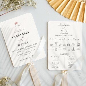 May include: A white wedding fan with a pink floral design and the text "Anastacia & Henry" and "Ceremony Begins at 4PM". The fan also includes a wedding timeline with icons for the ceremony, speeches, party time, cake and carriage.