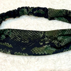 May include: A black and green headband with a snake skin pattern.