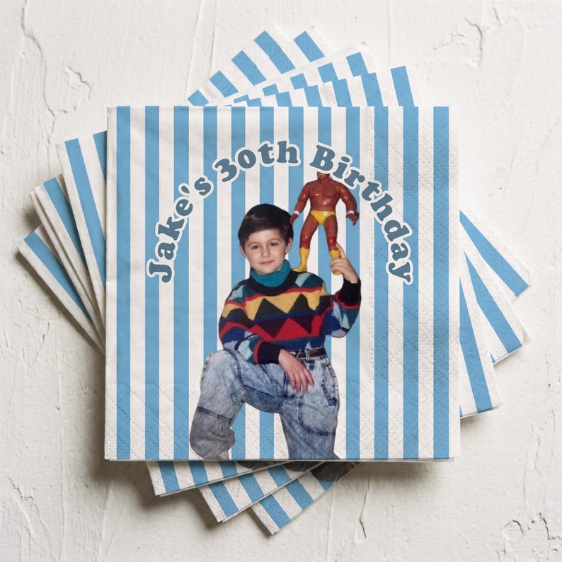 May include: A stack of square paper napkins featuring a light blue and white vertical striped pattern. The center displays a photograph of a child wearing a colorful geometric sweater and acid-wash jeans, holding a small wrestler action figure.