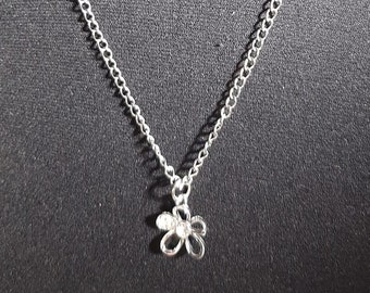 May include: A silver chain necklace with a small silver flower pendant.