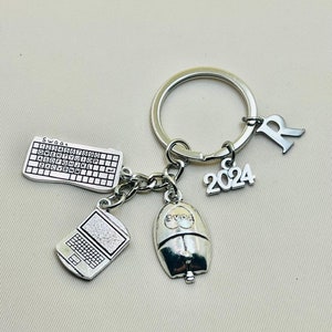 Könnte beinhalten: Silberner Schlüsselanhänger mit einem Computer-Tastatur-Anhänger, einem Laptop-Anhänger, einem Computer-Maus-Anhänger mit dem Wort "LOVE" darauf, einem Anhänger mit dem Jahr "2024" darauf und einem Anhänger mit dem Buchstaben "R" darauf.