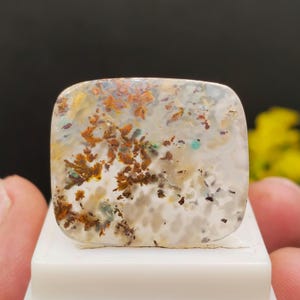 Copper chrysocolla gemstone featuring natural cloud-like patterns, accented by a chalcedony cabochon with copper inclusions; a rare gemstone