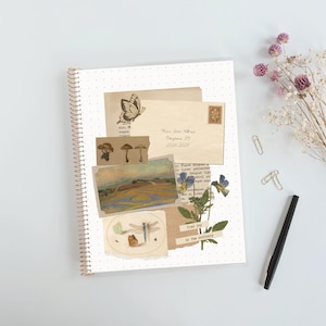 May include: A spiral-bound notebook with a white dotted cover featuring a collage of vintage-style paper scraps, a butterfly illustration, a landscape painting, mushroom drawings, a dragonfly, pressed flowers, and the text find joy in the ordinary.
