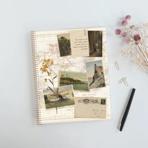 May include: A spiral-bound notebook featuring a vintage world map background decorated with collaged elements including a pressed yellow flower, several landscape photographs, a postcard, and a paper scrap with the text: The world is big and I want to have a good look at it before it gets dark. -John Muir.