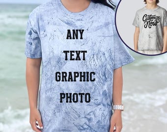 以下が含まれることがあります： 「ANY TEXT GRAPHIC PHOTO」の黒い文字が入った、水色のタイダイTシャツ。小さな画像には、「Customize Now」の文字が入った同様のシャツを着た子供が写っています。「OCEAN」という言葉が一番下にあります。