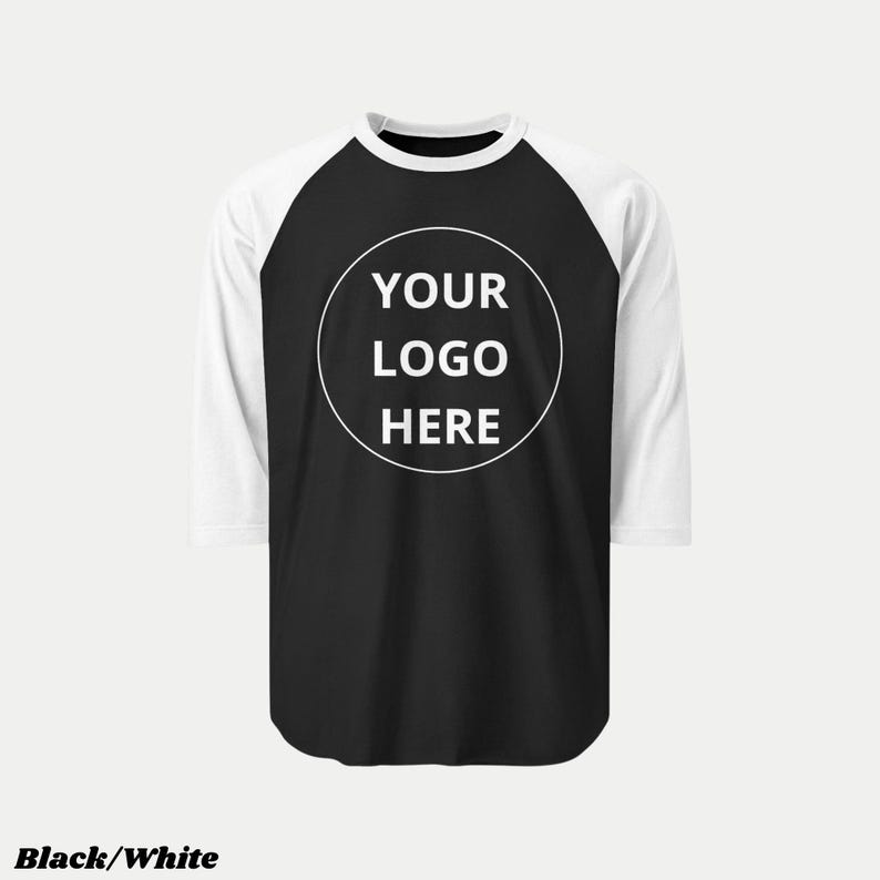 Pu&ograve; includere: Maglietta da baseball raglan bianca e nera con maniche a tre quarti. La maglietta ha un corpo nero, maniche e scollo bianchi. Un cerchio bianco sul davanti mostra il testo "YOUR LOGO HERE". Le parole "Black/White" sono in basso.