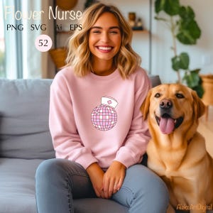 May include: A pink sweatshirt with a graphic of a disco ball wearing a pink nurse's hat. The text "Flower Nurse" is at the top of the image.