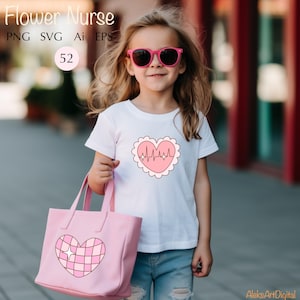 May include: A young person wearing a white t-shirt with a pink heart design featuring a heartbeat graphic. The heart has a white scalloped border. The person is holding a pink tote bag with a pink and white checkered heart design.