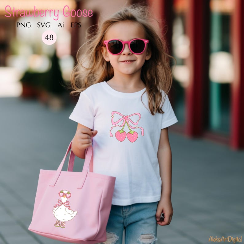May include: A young girl wearing a white t-shirt with a pink strawberry goose design and pink sunglasses. She is holding a pink tote bag with a strawberry goose design. The text "Strawberry Goose" is at the top of the image.
