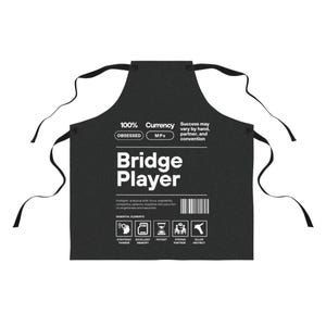 May include: Black apron with white text that reads "100% Currency, Obsessed, MPs, Bridge Player". The apron has a graphic of a brain, a memory card, an hourglass, two people playing cards, and a bullseye.