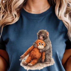May include: Navy blue t-shirt featuring a graphic of two monkeys hugging. One monkey is orange, the other is gray. The design is printed on a soft, crew neck tee.