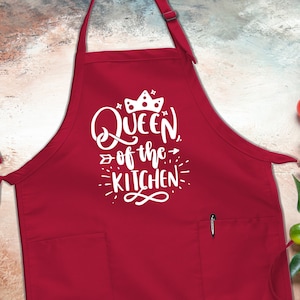 May include: Red kitchen apron with a white pocket and the text "Queen of the Kitchen" with a crown above the word "Queen".
