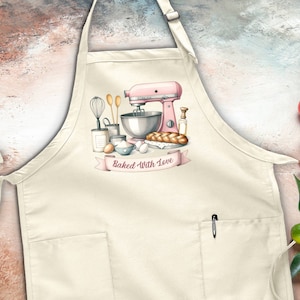 May include: A white cotton apron with a pocket and adjustable neck strap. The apron features a pink stand mixer, a bowl, and other baking supplies with the text "Baked With Love".