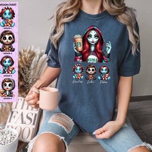May include: A navy blue t-shirt with a graphic of a cartoon character with red hair and a green and red striped shirt holding a cup of coffee. The character is labeled "Mama". Below the character are three smaller cartoon characters labeled "Emilia", "Luke", and "Nora".