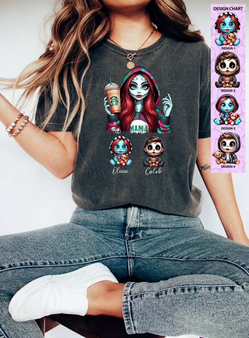May include: A dark gray t-shirt with a graphic print of a cartoon woman with red hair and blue skin holding a coffee cup. The text "MAMA" is printed on the shirt. Below the woman are two smaller cartoon figures with the names "Olivia" and "Caleb" printed below them. The shirt is being worn by a person.