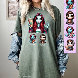 May include: Green t-shirt with a cartoon image of a woman with red hair and a green and black outfit holding a coffee cup. Below the woman are two smaller cartoon images of children with the names "Oliva" and "Caleb" written below them. The text "MAMA" is written on the woman's shirt. The t-shirt is shown on a model wearing a denim jacket.