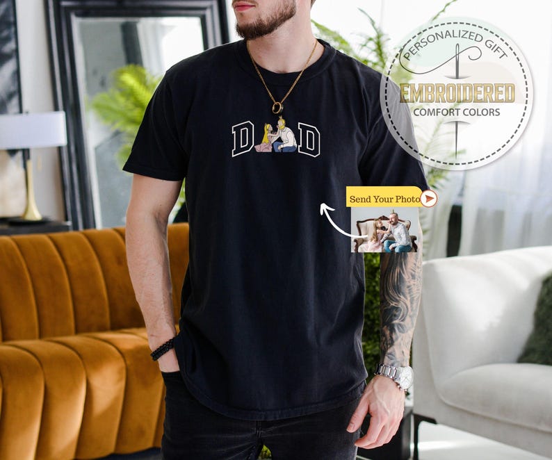May include: Black t-shirt with the word "DAD" in white block letters and a small image of a couple. The shirt has a round neck and short sleeves. The image also includes a "Send Your Photo" button.