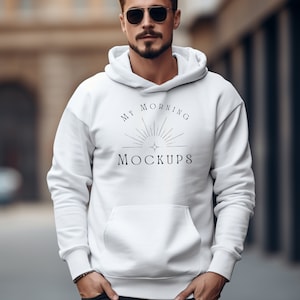 May include: A white hooded sweatshirt with the text "My Morning Mockups" printed on the front. The sweatshirt has a drawstring hood and a kangaroo pocket.