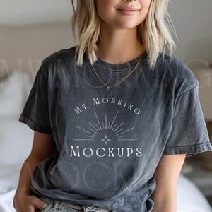 May include: Dark gray t-shirt with the text "MY MORNING MOCKUPS" in a white, stylized font. The design includes a sunburst graphic. The shirt has a vintage, washed appearance.