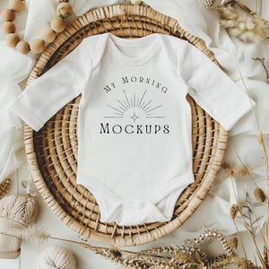 Könnte beinhalten: Weißer langärmliger Baby-Body mit dem Text "My Morning Mockups" und einem Sonnenstrahlen-Design.