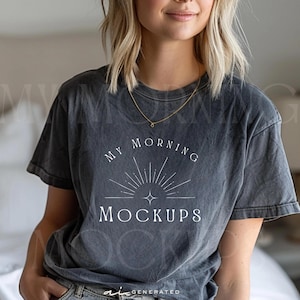 Könnte beinhalten: Ein anthrazitfarbenes Kurzarm-T-Shirt mit Vintage-Waschung. Auf der Vorderseite befindet sich eine weiße Grafik eines Sonnenstrahlendesigns über dem Text "MY MORNING MOCKUPS" in Serifenschrift. Das T-Shirt hat einen Rundhalsausschnitt und eine lockere Passform.