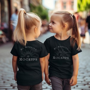 May include: Two children wearing black t-shirts with the text "My Morning Mockups" in white. The children are standing on a sidewalk.