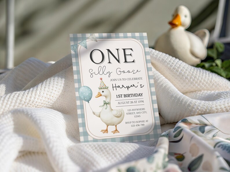 May include: A birthday invitation with a whimsical design. The invitation features a cartoon goose holding a balloon, with the text "ONE Silly Goose" and event details. The background is a light blue gingham pattern.
