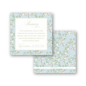 May include: A square card featuring a light blue background with a pattern of brown branches, green leaves, and white flowers. The text reads January, Lamentations 3:22-23, and a verse about the steadfast love of the Lord. A second card is partially visible.