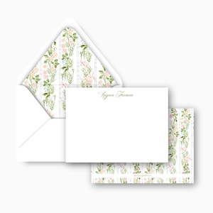May include: A stationery set featuring a white envelope, a blank card, and a patterned card. The envelope interior and patterned card display a floral design with pink, peach, and green flowers. The blank card has the name "Kayson Freeman" printed in green.