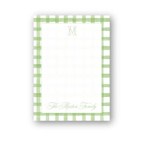 May include: A rectangular notepad with a green and white gingham border. The notepad features a centered initial "M" and the text "The Morton Family" in a script font. The background is white.