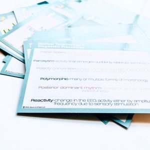 May include: A stack of blue and white flashcards with medical terminology related to diagnostic procedures. The terms include "Paroxysm", "Polymorphic", "Posterior dominant rhythm", and "Reactivity".