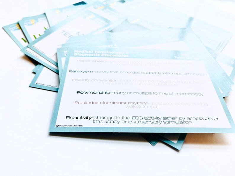 May include: A stack of blue and white flashcards with medical terminology related to diagnostic procedures. The terms include "Paroxysm", "Polymorphic", "Posterior dominant rhythm", and "Reactivity".