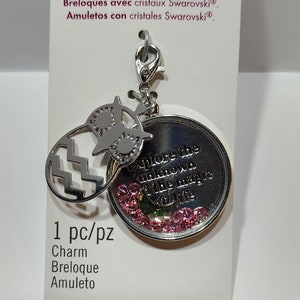 May include: A silver-toned metal charm featuring an owl silhouette and a circular pendant with the text Explore the unknown the magic of life, accented with small pink crystals. The charm is attached to a lobster clasp on a white display card.